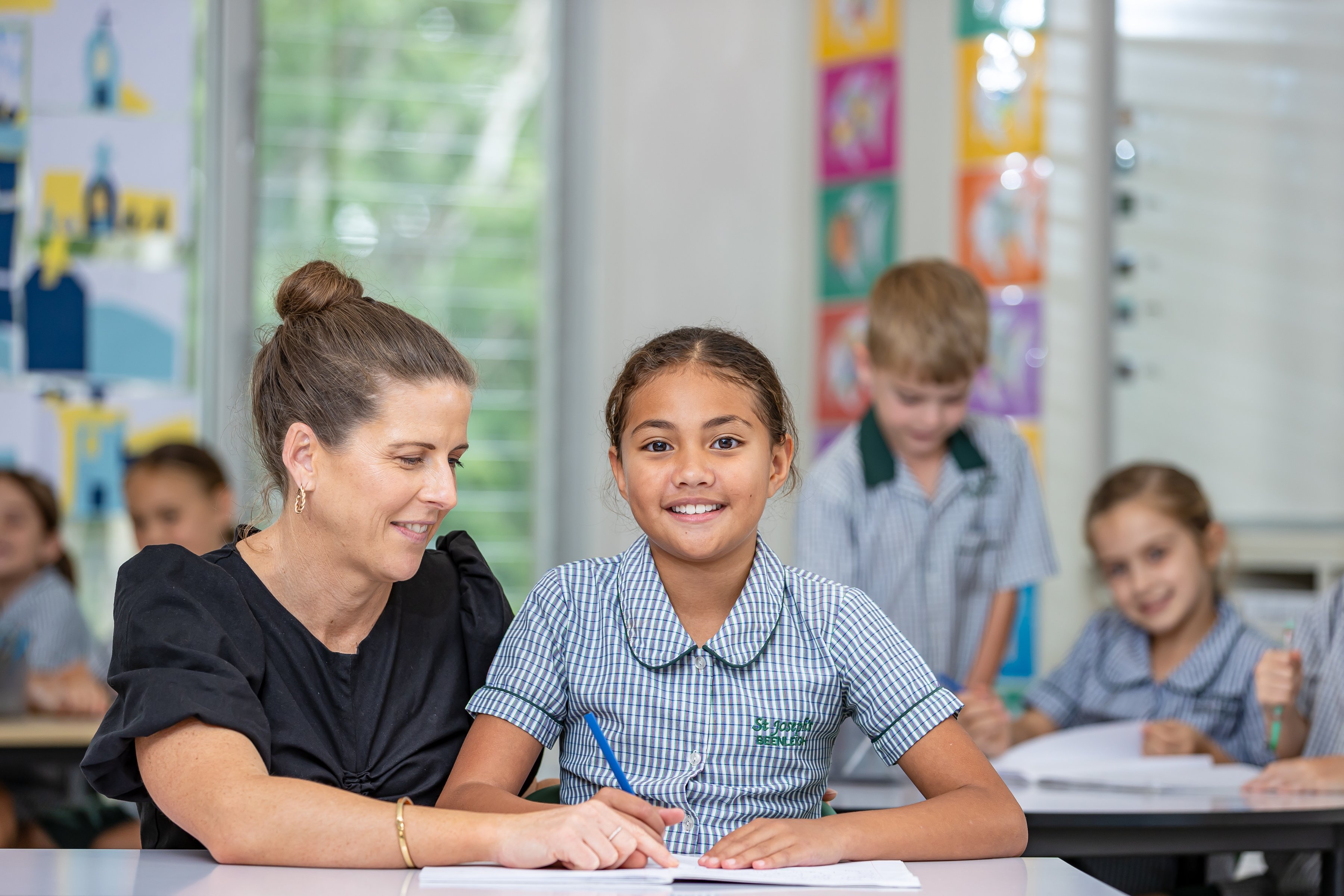 Student working with teacher and smiling